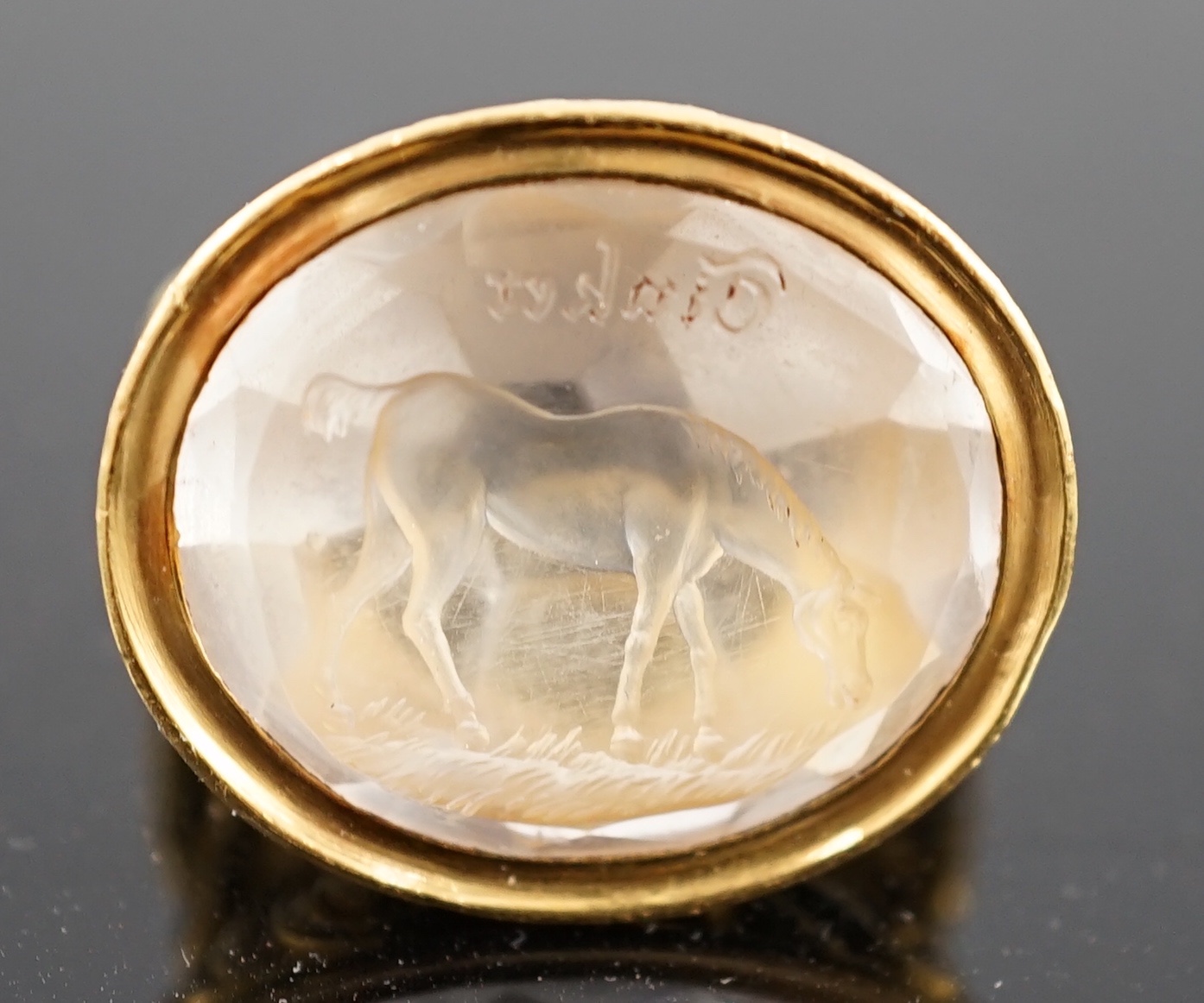 A large antique style gold and intaglio white stone set ring